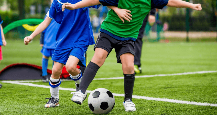 young soccer player dribbling ball