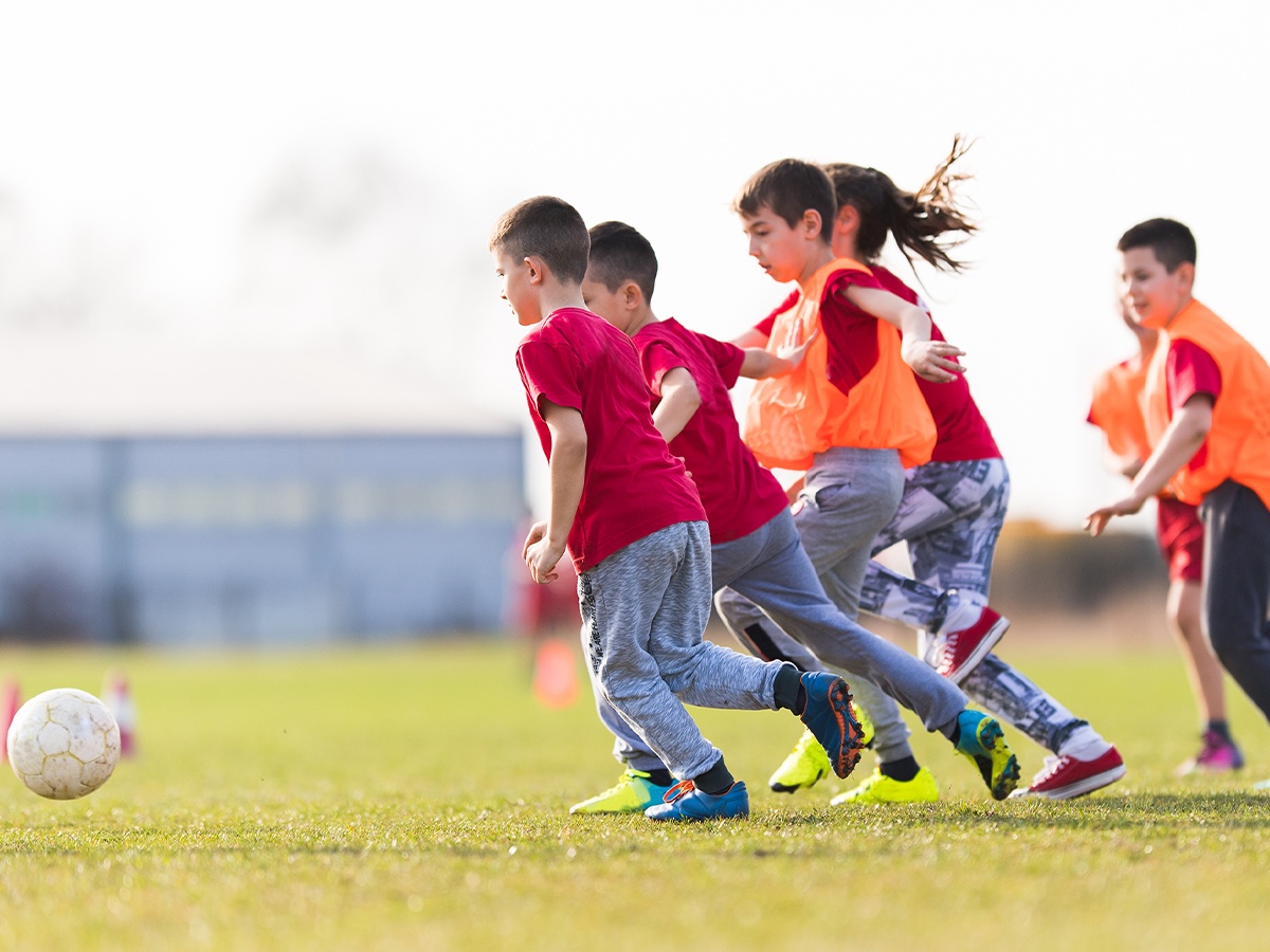 group of youth soccer players chasing after the ball