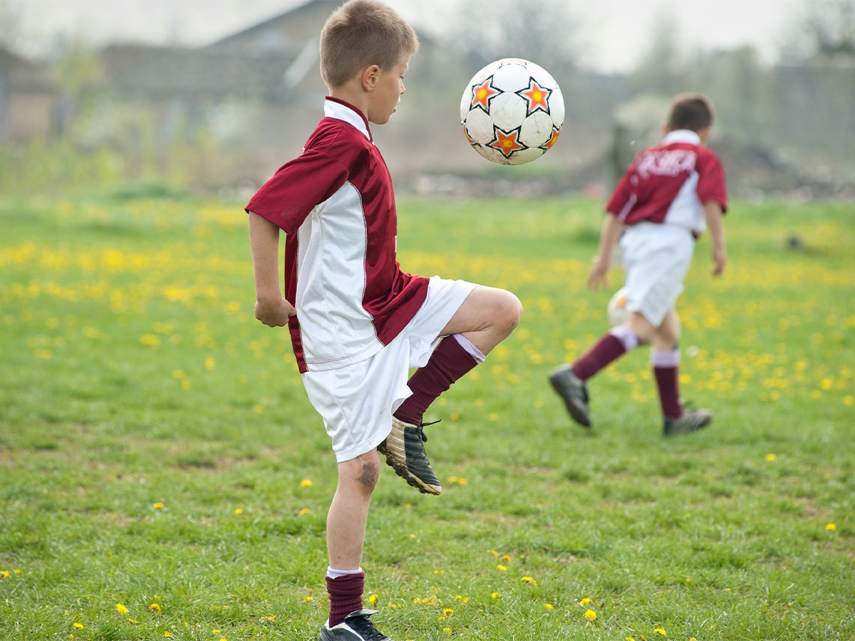 Boy juggling soccer ball