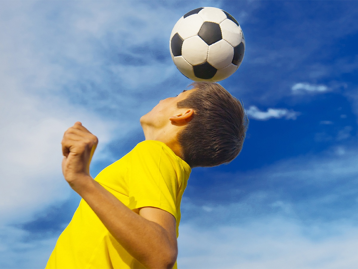 Boy jumping for head ball